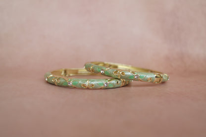 Anarkali enamel bangle by Rangat — coral flowers bloom across a rich green canvas