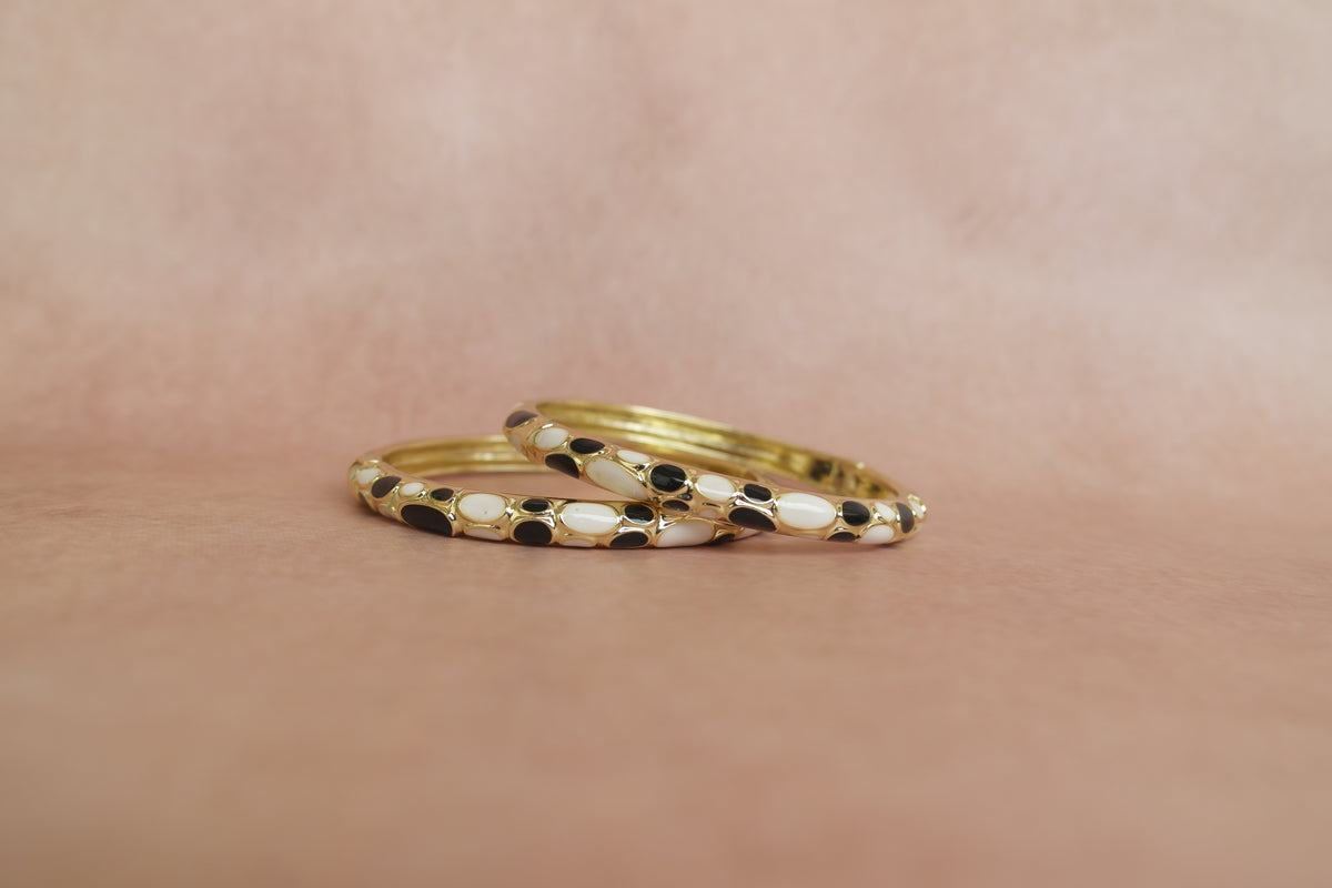Siyah Sadaf enamel bangle by Rangat — glossy black and ivory forms sit in a golden frame