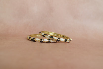 Siyah Sadaf enamel bangle by Rangat — glossy black and ivory forms sit in a golden frame
